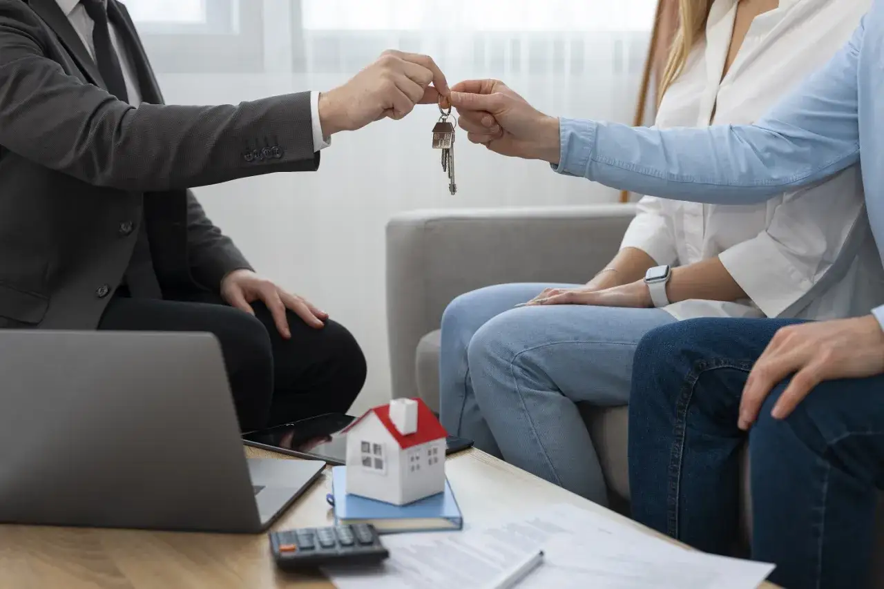 Agente immobiliare consegna chiavi a coppia. L'obbligo dell'inquilino di consentire la visita dell'agenzia per la vendita è rispettato.