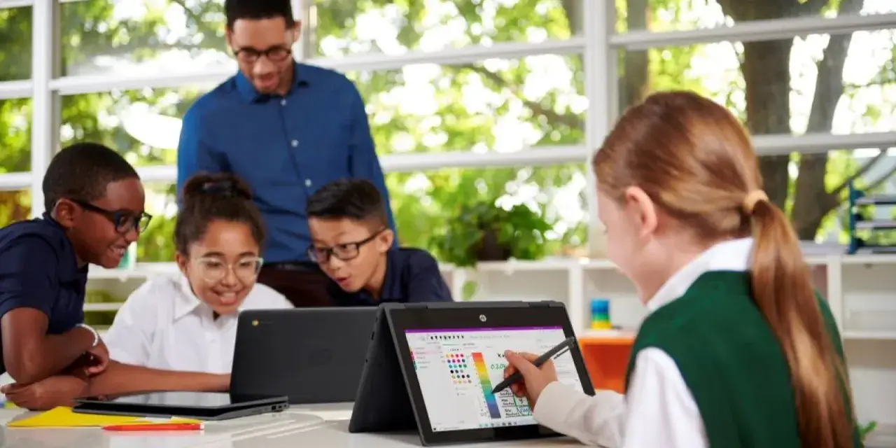 Lehrer und Sch&uuml;ler arbeiten mit Laptops. Die Frage 