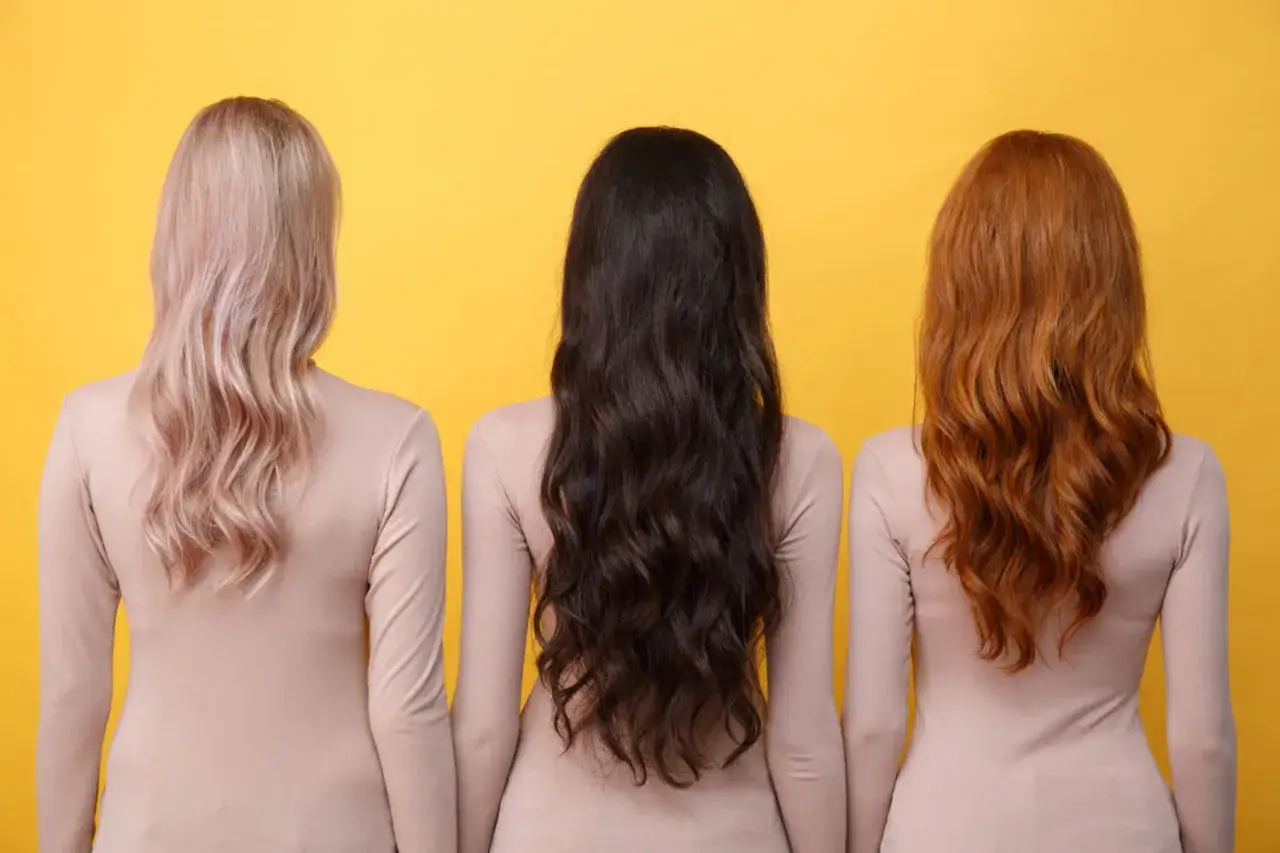 Trzy kobiety z długimi włosami: blond, brunetka i rudowłosa. Każda z nich świętuje swój rok zapuszczania włosów, prezentując ich piękno.