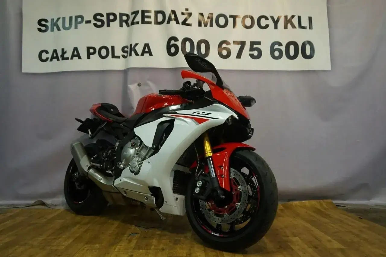 Sportowy motocykl Yamaha R1 2015 w czerwono-białej kolorystyce, gotowy do jazdy.