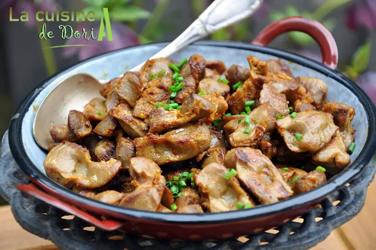 Délicieuse recette gésier de poulet poêlée, garnie de ciboule fraîche, servie dans un plat émaillé.