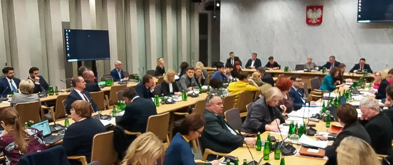 Obrady w sali plenarnej, gdzie członkowie komisji edukacji narodowej dyskutują nad ważnymi sprawami.