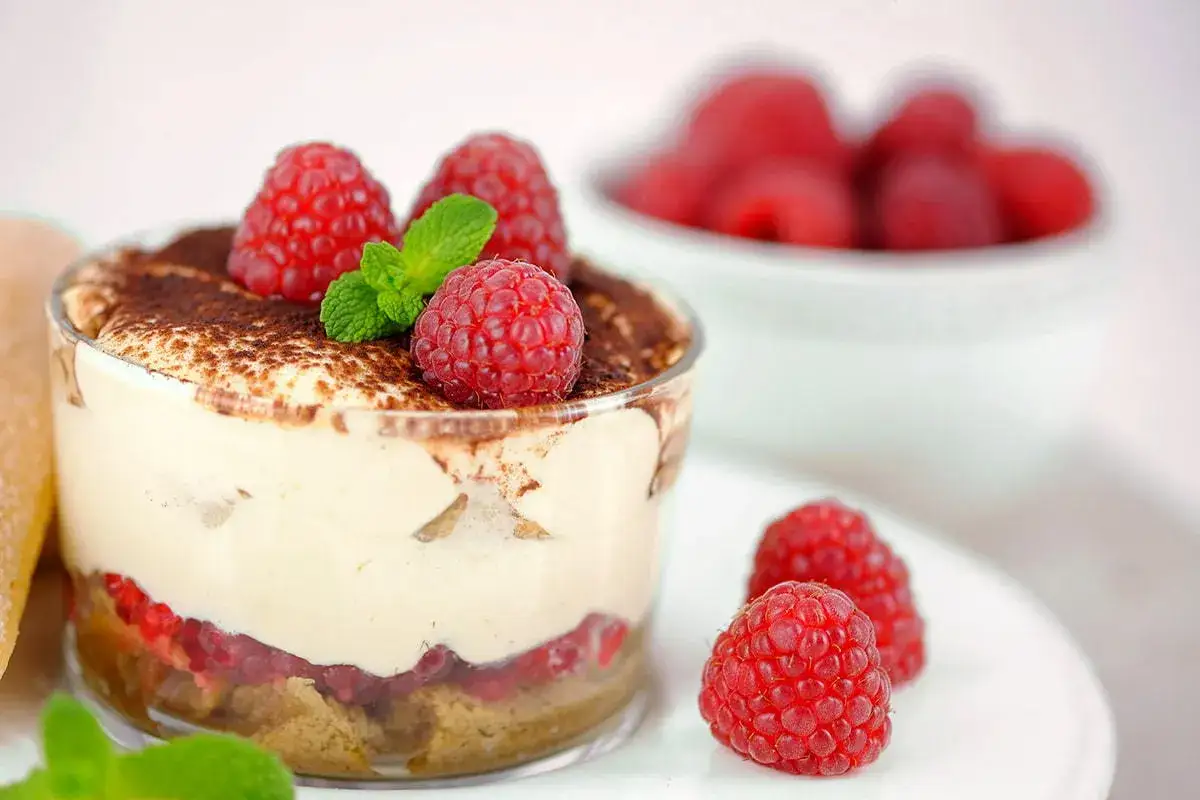 Himbeer Tiramisu im Glas, garniert mit frischen Himbeeren und Minze. Ein k&ouml;stlicher Nachtisch, der Lust auf mehr macht.