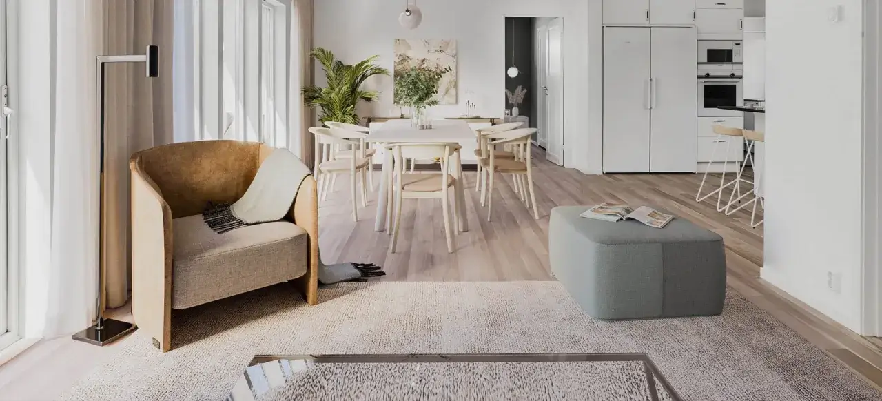 Ett ljust och luftigt vardagsrum med matplats i skandinavisk design inredning. En bekväm fåtölj, ett runt matbord med stolar och en grön sittpuff.
