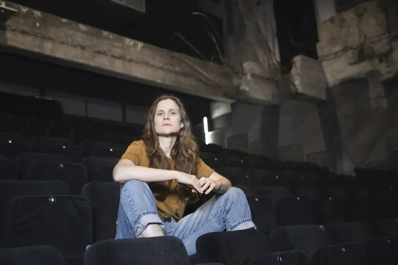 Federica Rosellini seduta tra le file vuote di un cinema, con uno sguardo pensieroso.
