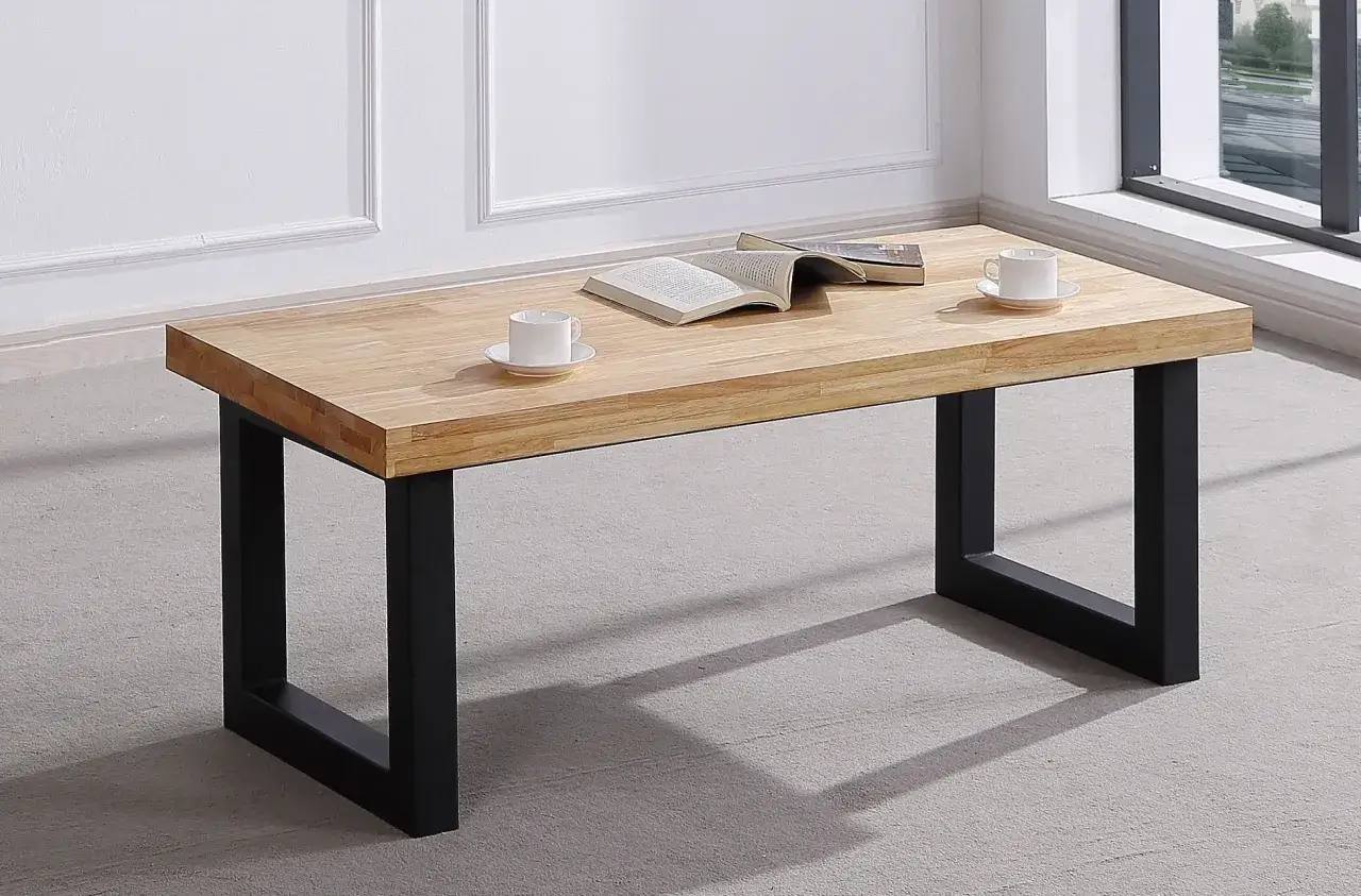 Mesa centro elevable 120x70 de madera clara con patas negras. Dos tazas y un libro abierto sobre ella.