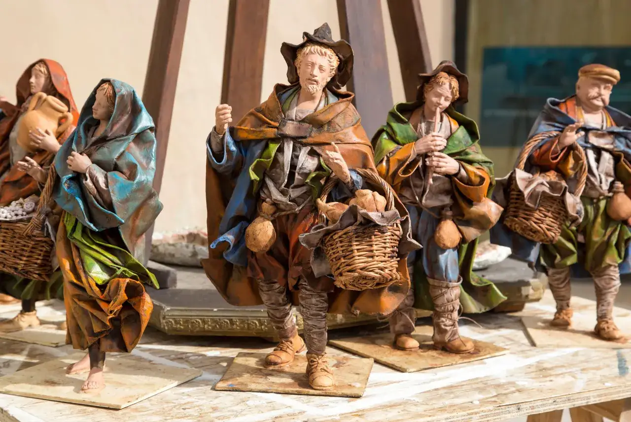 Statue di artigiani che rappresentano antichi mestieri siciliani, con cesti e anfore.