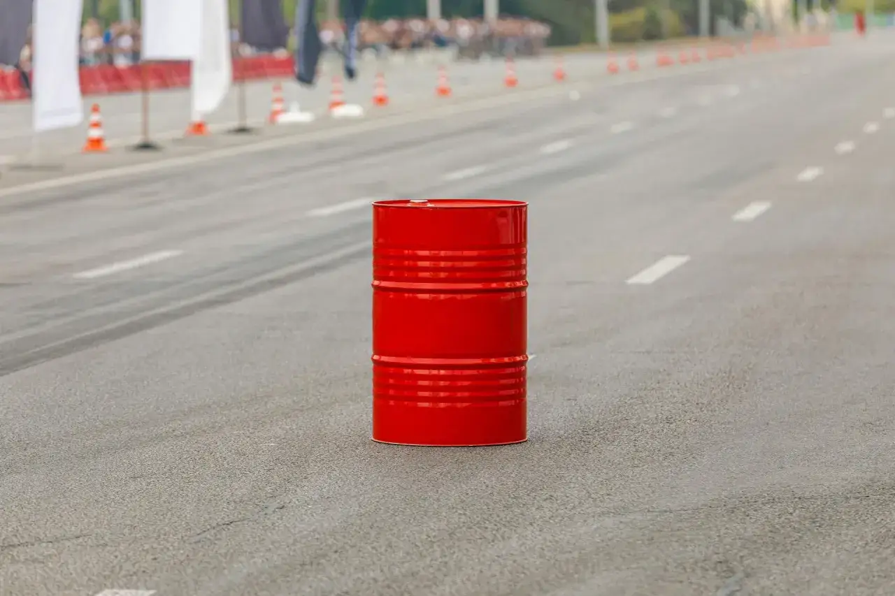Un bidone rosso su una strada, forse un ostacolo per una gara di **art 161 cds**.