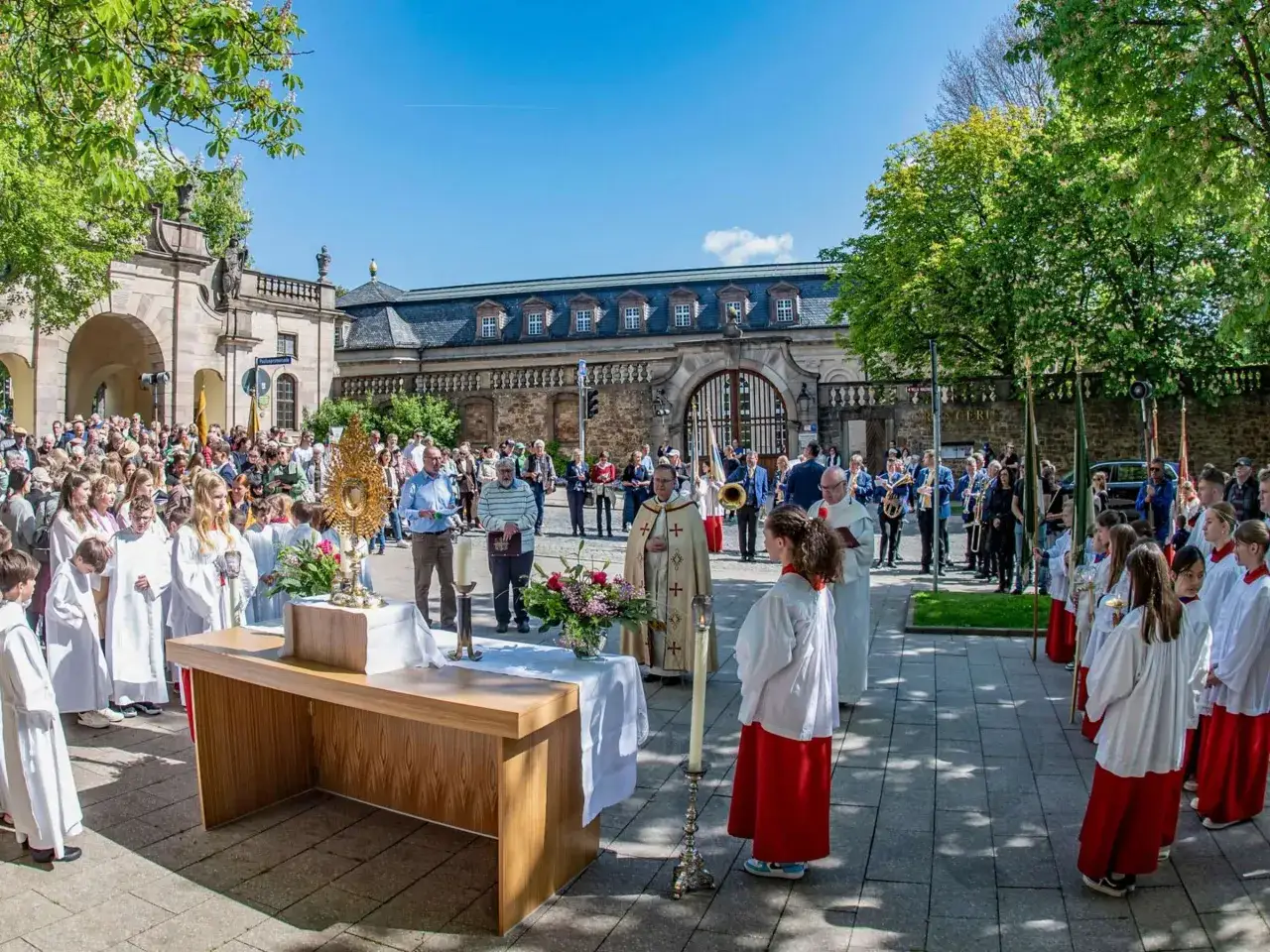 Feierliche Prozession zur Himmelfahrt 26. Mai mit Ministranten und Gl&auml;ubigen vor historischer Kulisse.