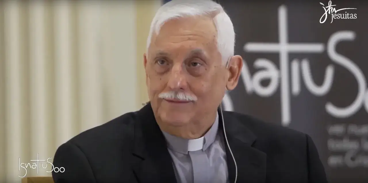 Starszy mężczyzna w czarnym papieskim stroju, z siwymi włosami i wąsami, uśmiecha się.