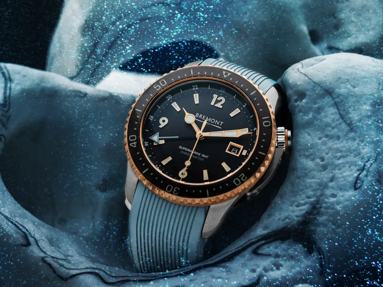Bremont Supermarine GMT, zegarek z funkcją gtm czas, otoczony błękitnymi, wodnymi falami.