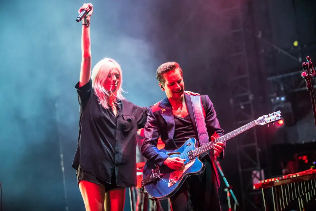 Daria Zawiałow i Dawid Podsiadło na scenie, ona z mikrofonem w górze, on gra na gitarze.