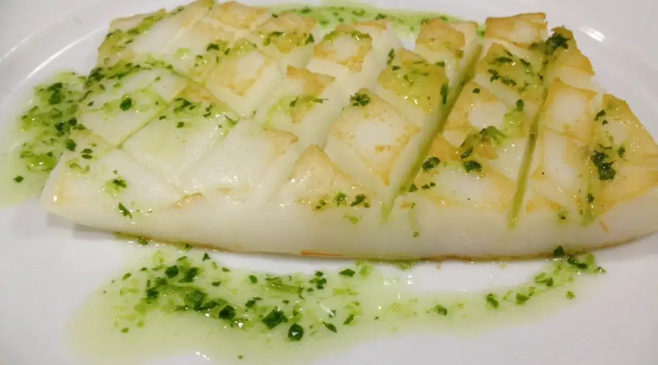 Calamares a la plancha con cortes en rombos, ba&ntilde;ados en una deliciosa salsa mery verde con perejil picado.