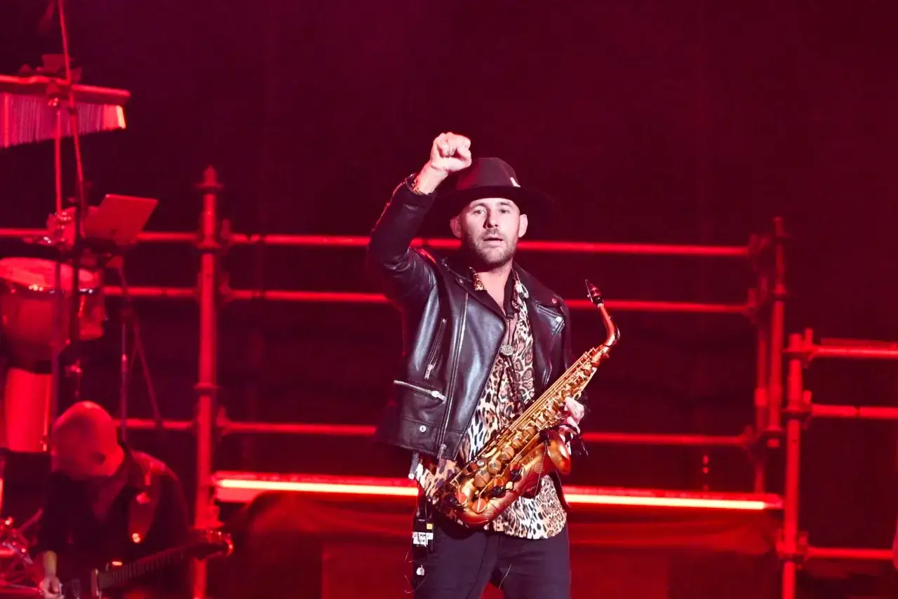 Jimmy Sax, con il suo inconfondibile cachet, sul palco con sax e pugno alzato.