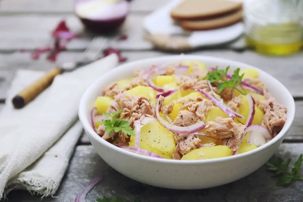 Insalata di patate e tonno, un piatto fresco e saporito, con cipolla rossa e prezzemolo.