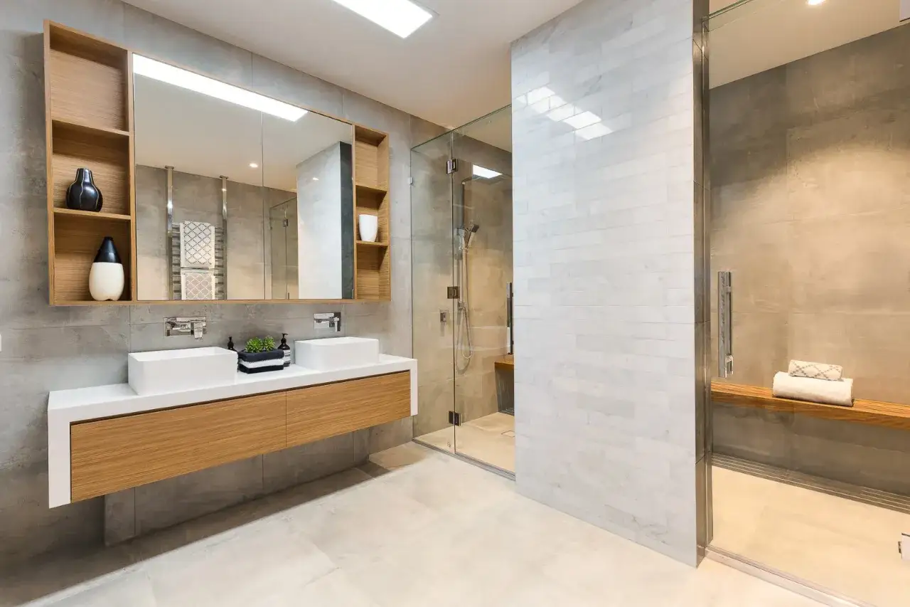 Ein luxuriöses, modernes Badezimmer mit Doppelwaschbecken, bodentiefer Dusche und Holzakzenten.