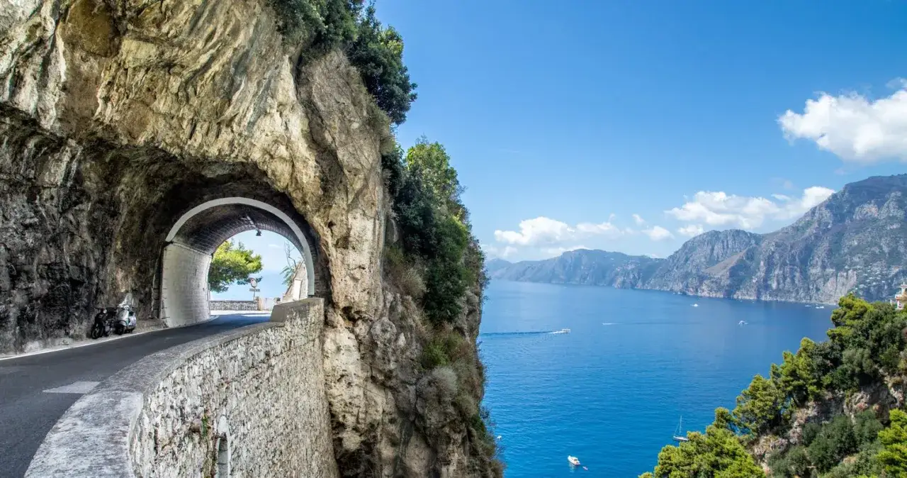 A scooter waits by a tunnel on the Amalfi Coast, hinting at the freedom of exploration. Should you rent a car in Amalfi Coast? This view suggests yes!