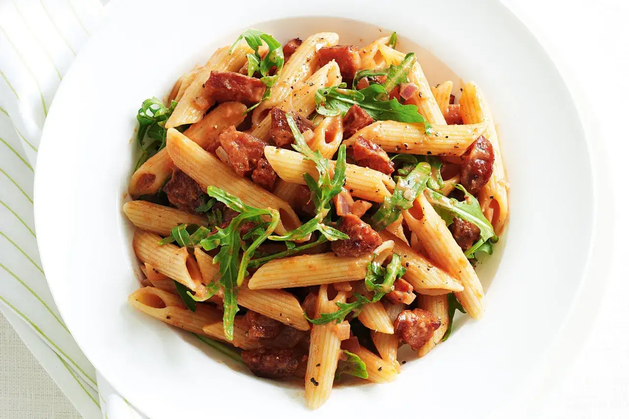 En skål med penne pasta med bitar av kryddig chorizo och färsk ruccola. Enkel och smakrik pasta med chorizo.