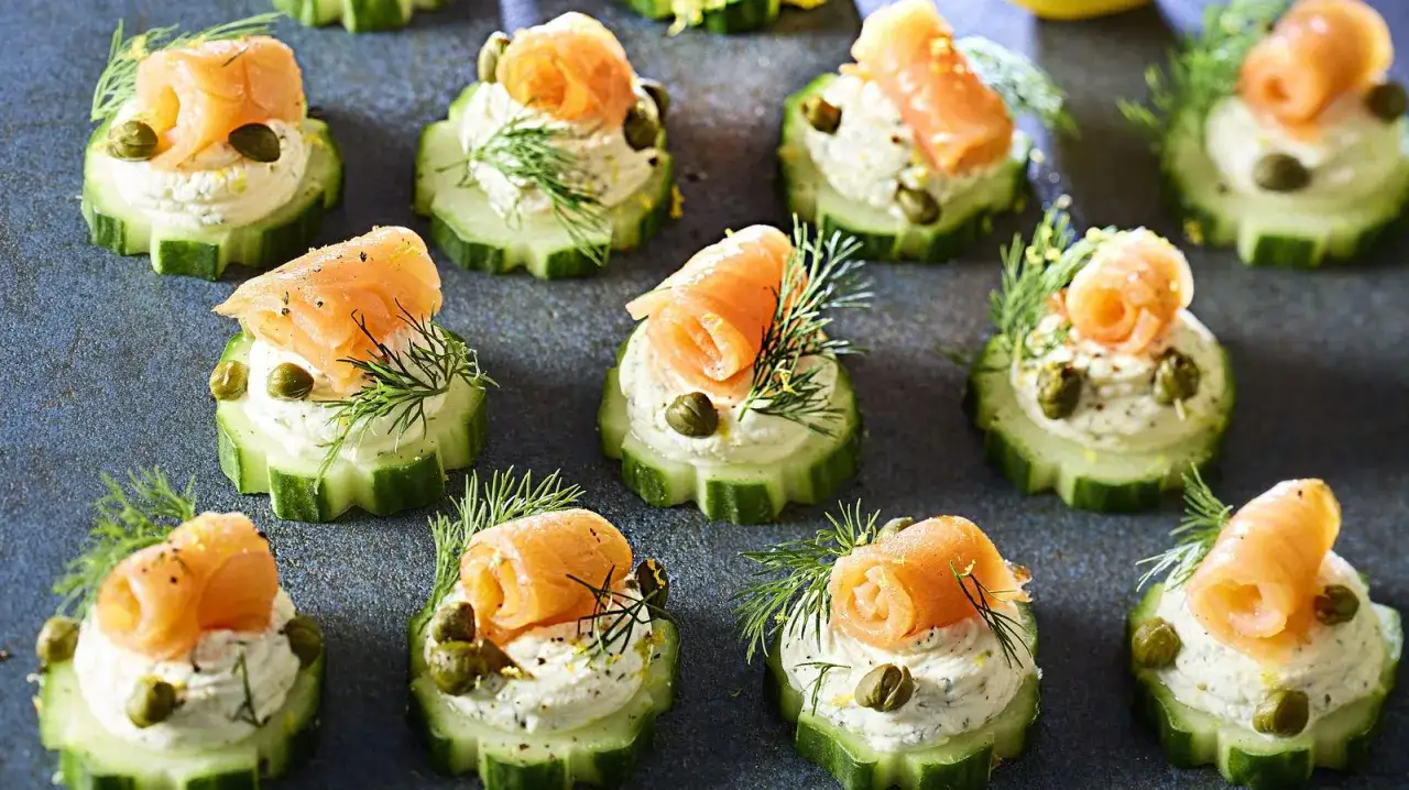 Kleine Gurkenscheiben mit Frischkäse, Räucherlachs, Kapern und Dill – perfekte Snacks zum Aperitif.