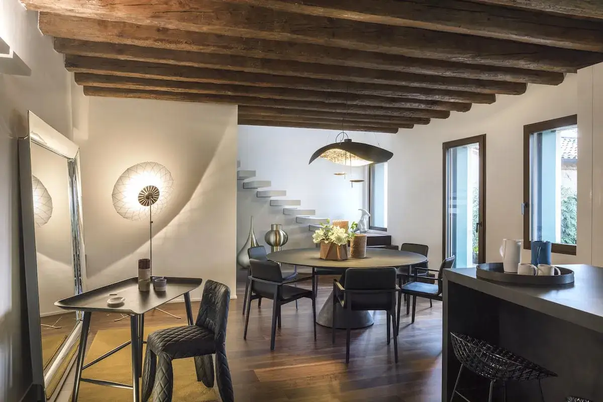 Interni moderni con travi a vista, pro e contro: un soffitto rustico dialoga con arredi di design, creando un contrasto affascinante.