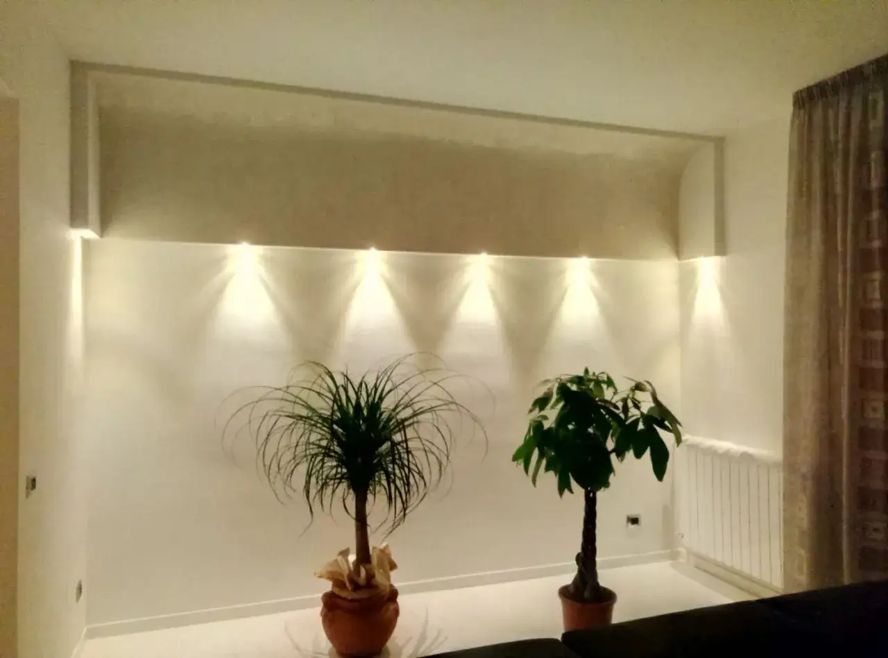 Elegante nicchia illuminata, una vetrinetta in cartongesso che valorizza due piante verdi.