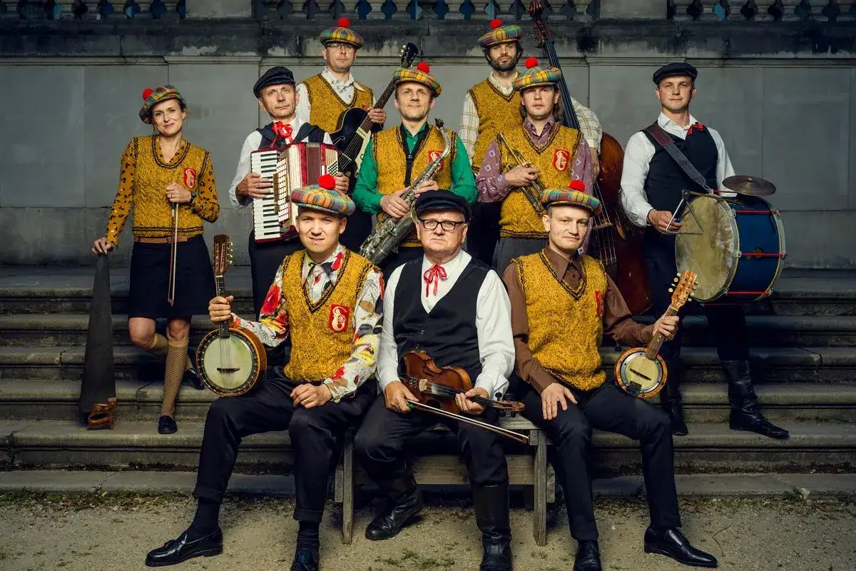 Warszawskie combo taneczne w szkockich beretach gra na instrumentach: banjo, skrzypcach, akordeonie, saksofonie, kontrabasie i bębnach.