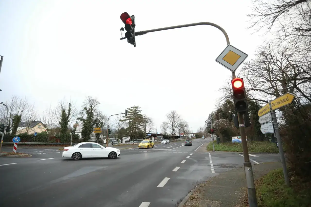 Ampel zeigt Rot. Ein wei&szlig;er Mercedes f&auml;hrt auf der Stra&szlig;e. 132 bkat.