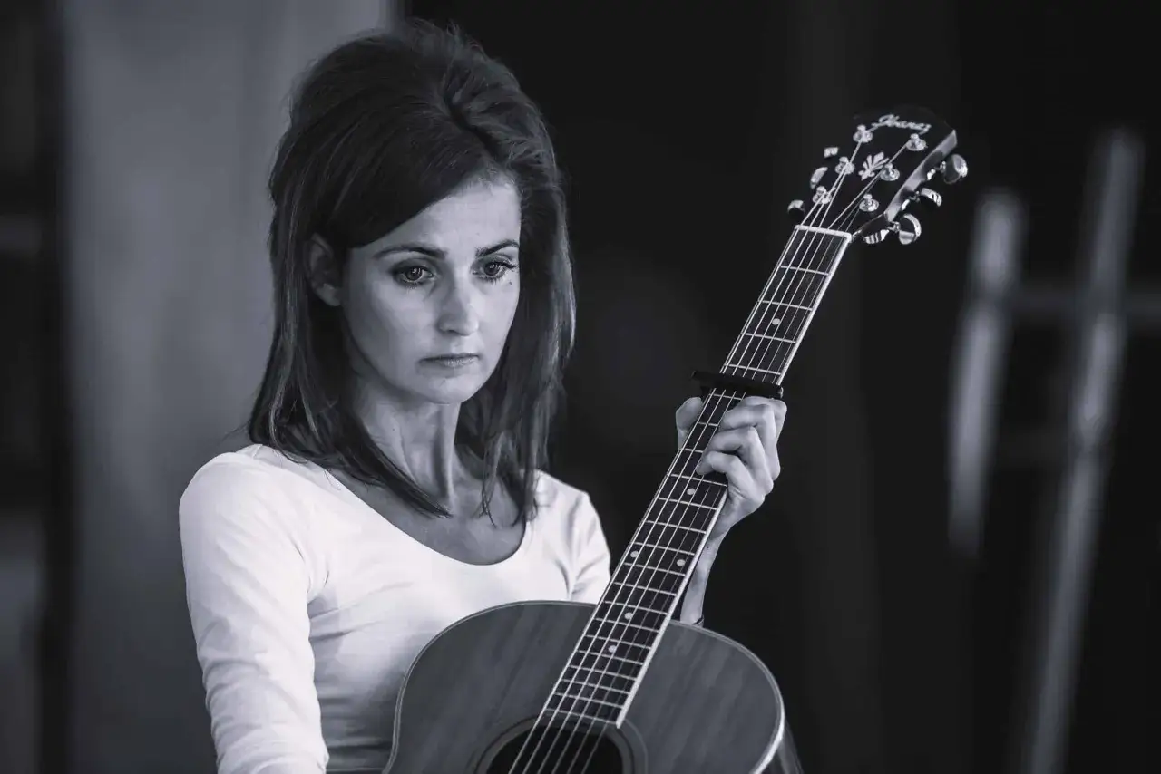 Dominika Żukowska, zamyślona, z gitarą w dłoniach. Data urodzenia nieznana, ale jej muzyka żyje.