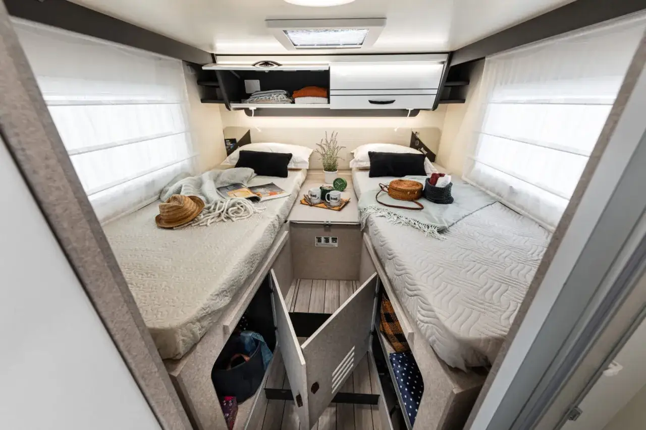 Chambre de camping-car Mc Louis avec deux lits jumeaux, rangements sous les lits et placards. Parfait pour une fiche technique.