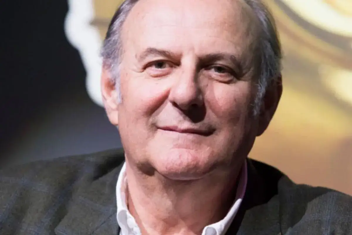 Primo piano di Gerry Scotti, un uomo sorridente con capelli grigi. Quanti anni ha Gerry Scotti? La sua esperienza parla da s&eacute;.