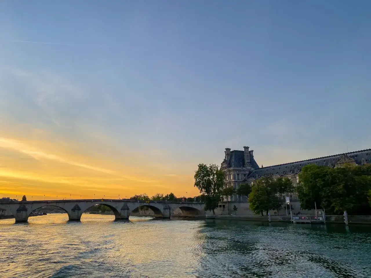 Magnifique coucher de soleil sur la Seine, un pont majestueux et le Louvre. Une belle visite Paris Seine.