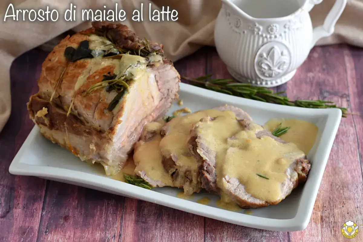Arrosto di maiale al latte, succulento e profumato, servito su un piatto bianco con salsa cremosa e rosmarino.