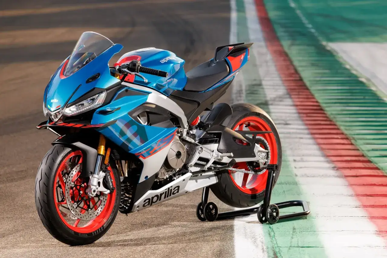 Aprilia RS 660 con sus 100 cv, lista para la pista. Dise&ntilde;o deportivo en azul y rojo, con llantas rojas vibrantes.