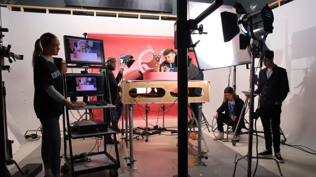 Team al lavoro per un **stop motion film**. Luci, monitor e set con personaggi colorati.