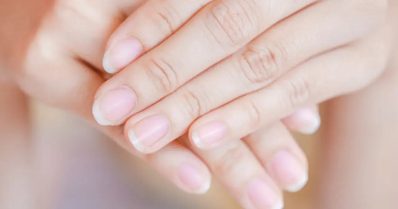 Delikatne dłonie z naturalnymi paznokciami, idealne do zabiegu manicure biologicznego.
