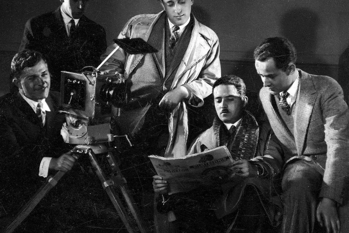 Grupa mężczyzn przy kamerze filmowej, być może podczas pracy nad jednym z filmów Michała Waszyńskiego.