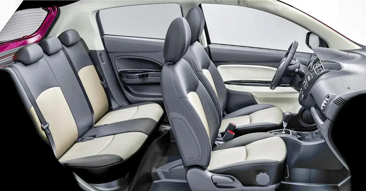 Wnętrze Mitsubishi Space Star 2004: dwukolorowe siedzenia, deska rozdzielcza i kierownica.