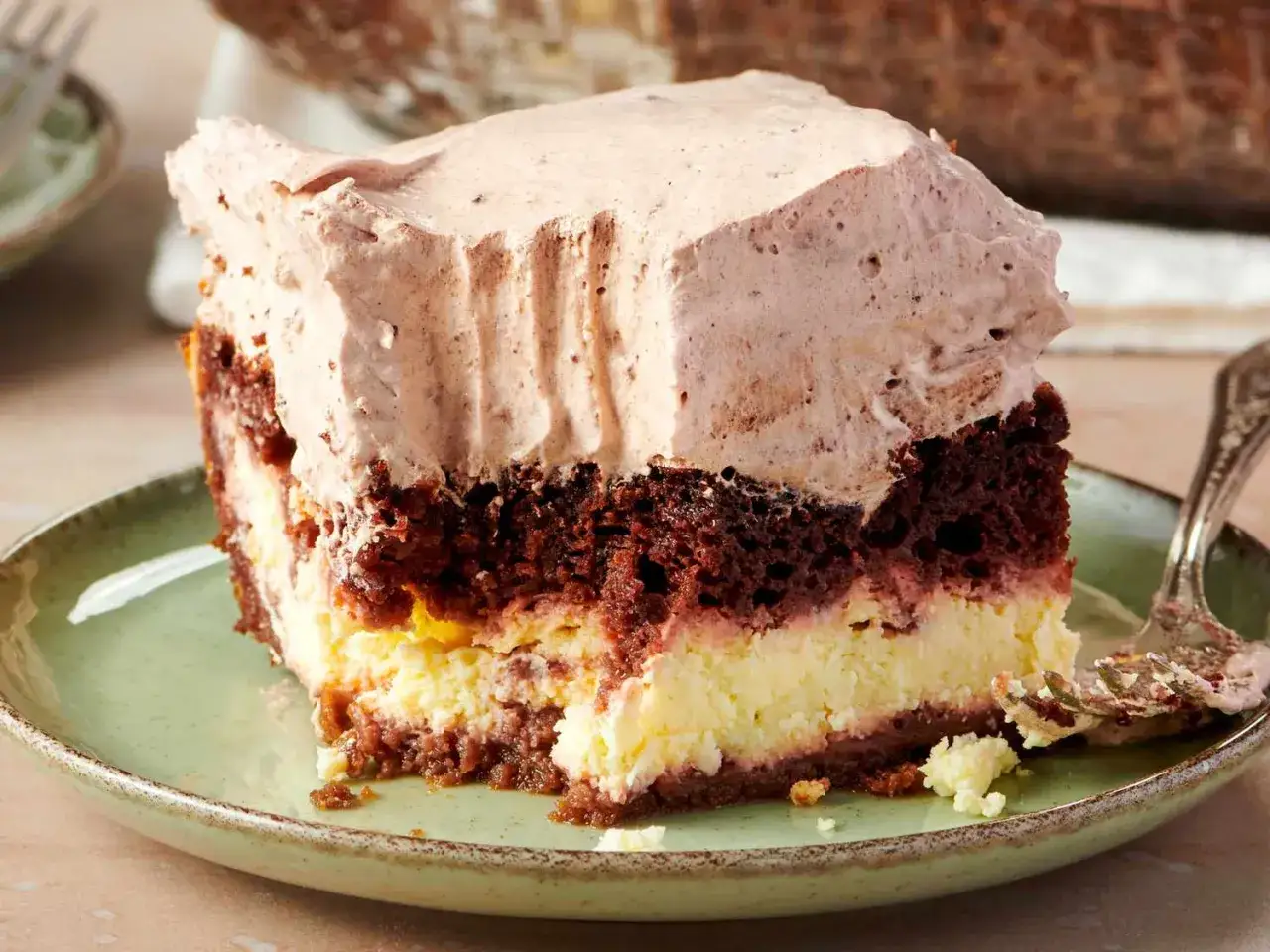 Kawałek pysznego ciasta zuppa inglese z warstwami czekoladowego biszkoptu, kremu i bitej śmietany.