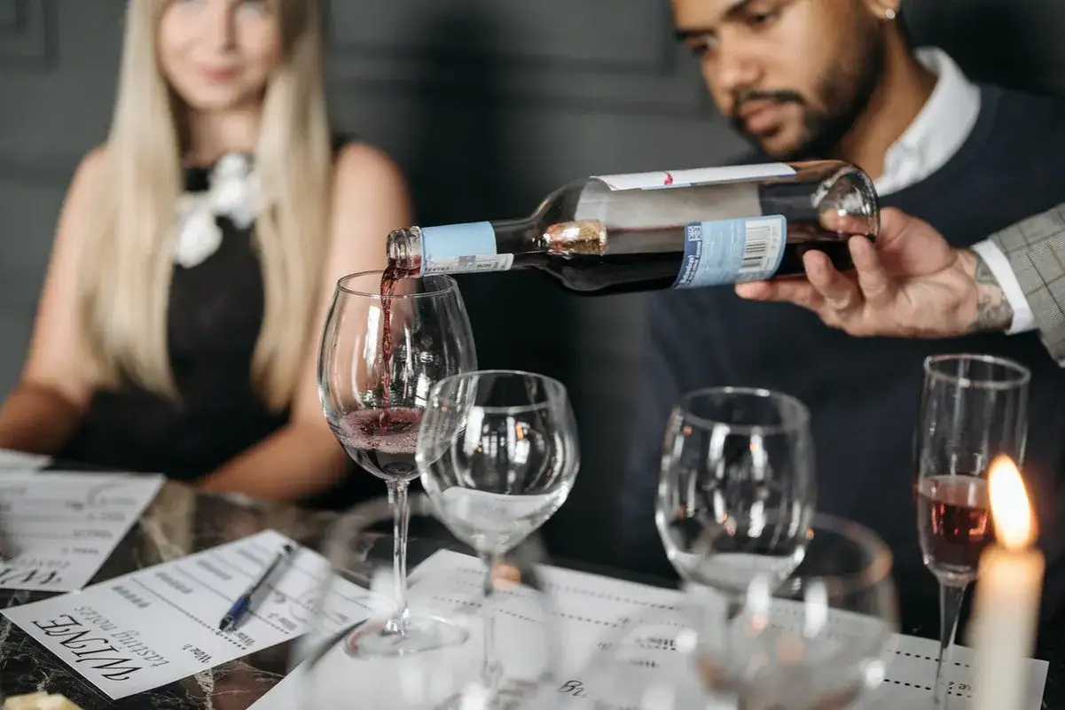 Ein Sommelier schenkt Rotwein ein. Die Bedeutung eines Sommeliers liegt in der Weinberatung und -pr&auml;sentation.