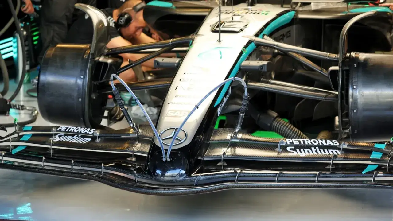 Detailaufnahme eines Formel 1-Boliden, bereit für 300 km/h. Mechaniker im Hintergrund.
