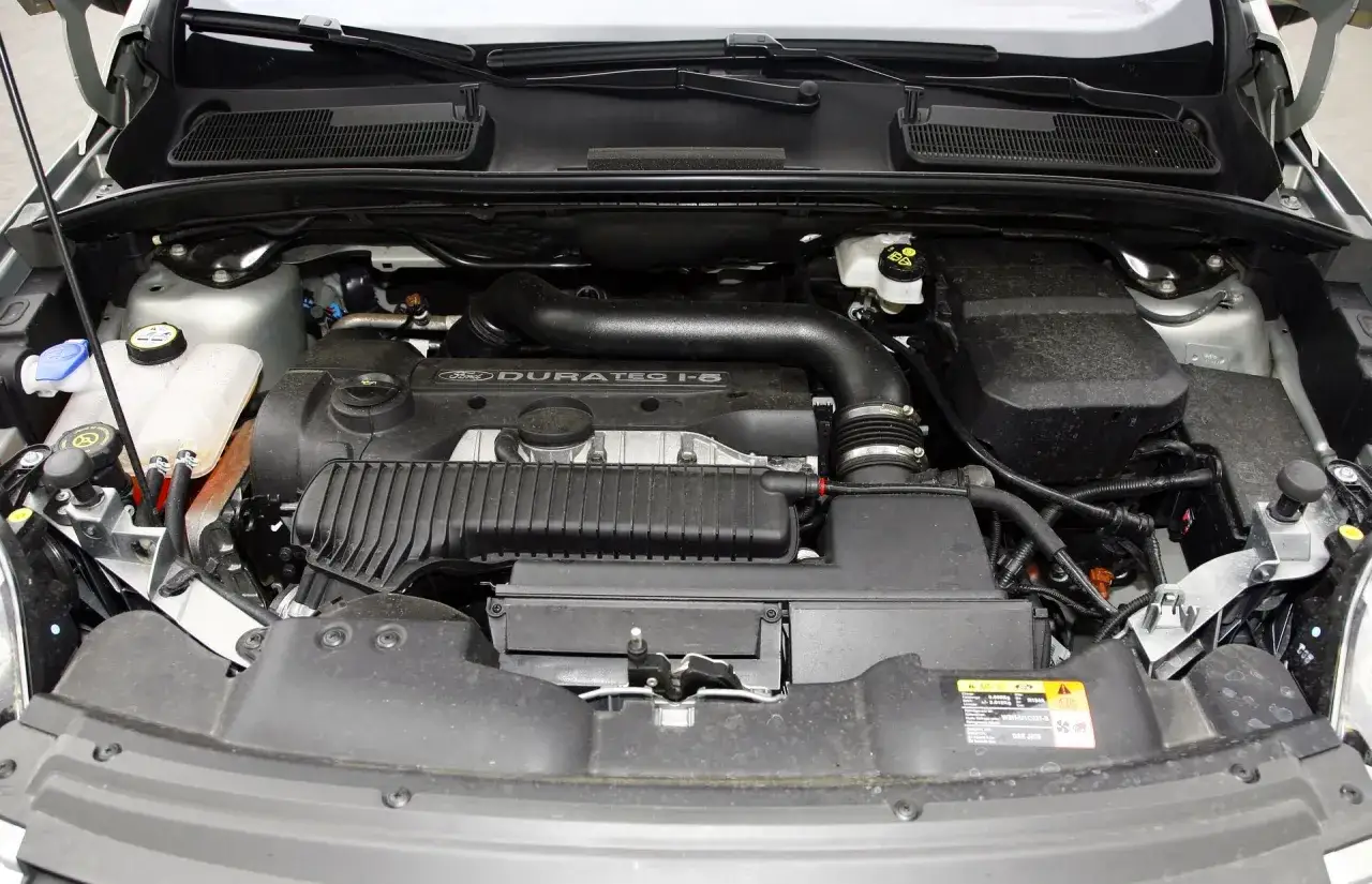 Silnik Duratec 1-5 w Fordzie Kuga 2010. Widoczne przewody, zbiorniczki i elementy osłony silnika.