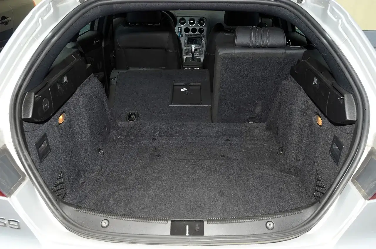 Pusta przestrzeń bagażowa Alfa Romeo 159 1.9 JTD, gotowa na podróż.
