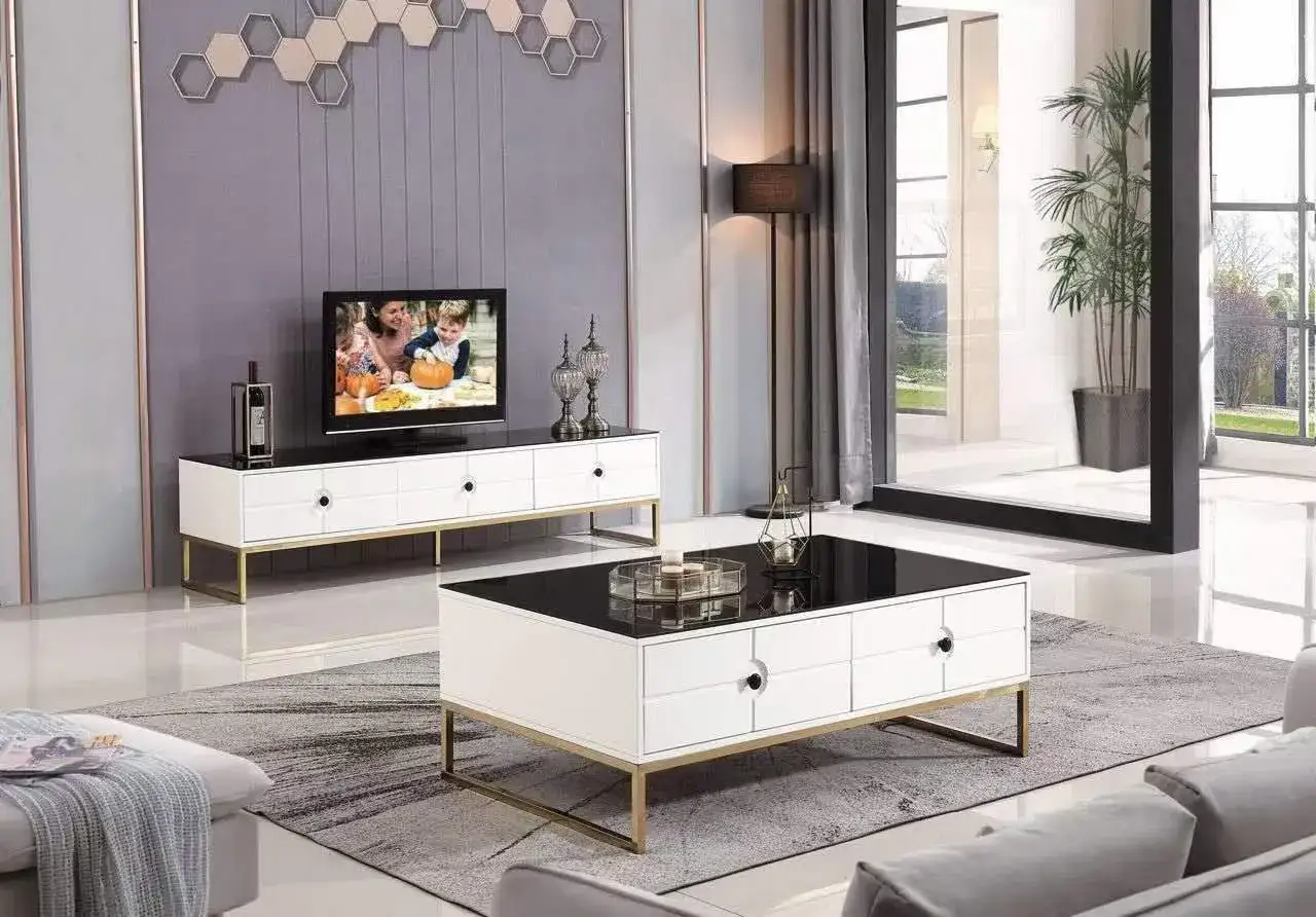 Modernt vardagsrum med en vit tv b&auml;nk guld, soffbord och en stor spegel.