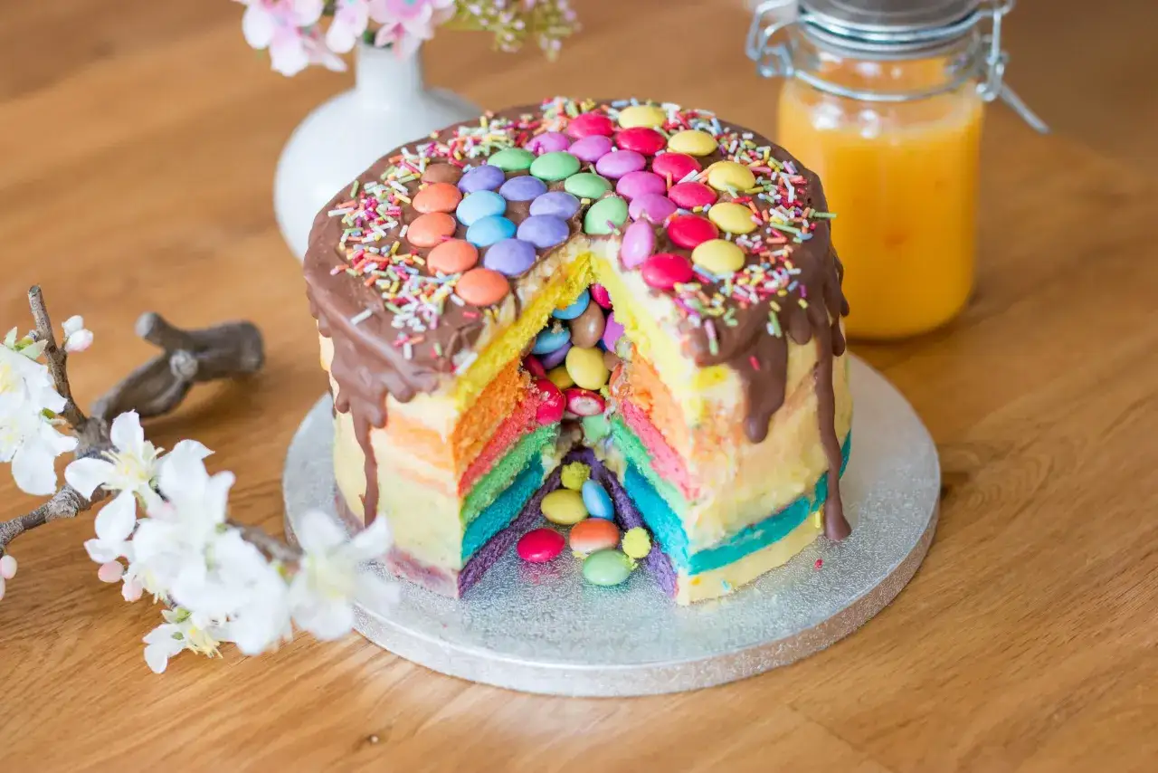 Bunter Smarties Kuchen mit Schokoladenglasur und Streuseln, ein Fest für die Augen und den Gaumen.