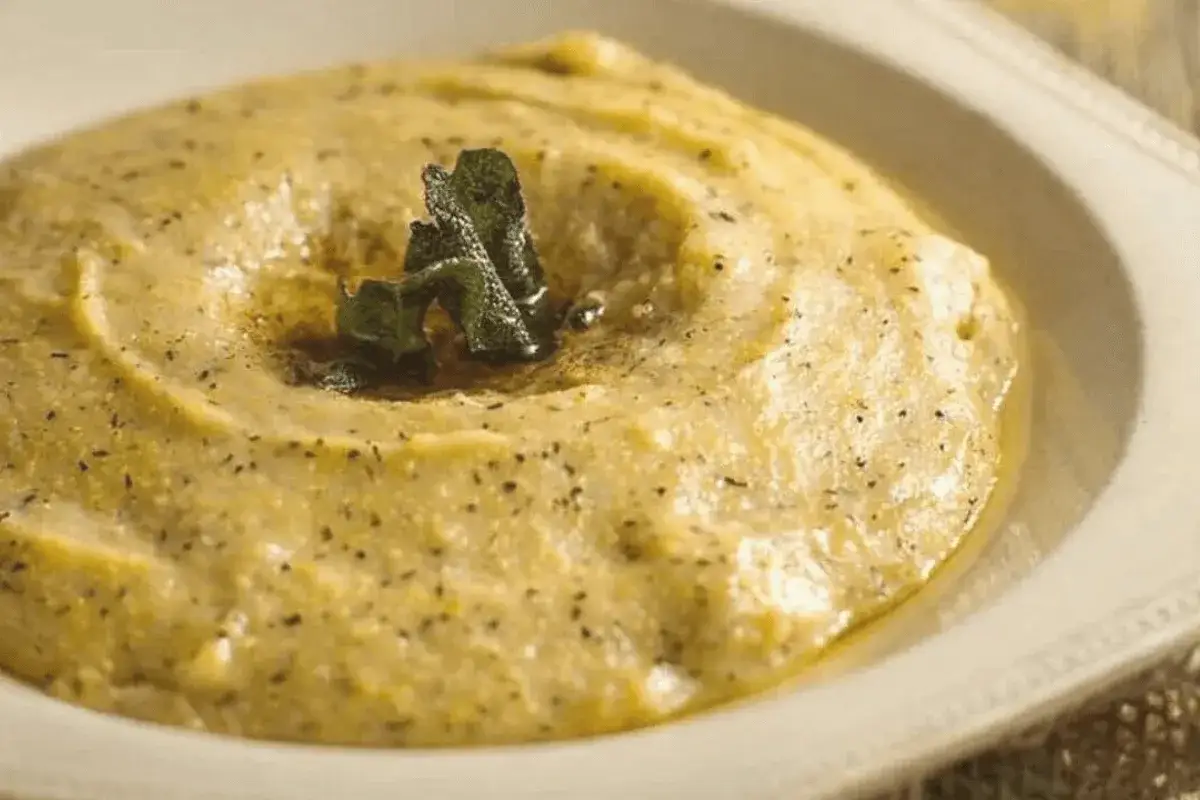 Polenta cremosa, uno dei piatti tipici bergamaschi, guarnita con salvia e pepe nero.