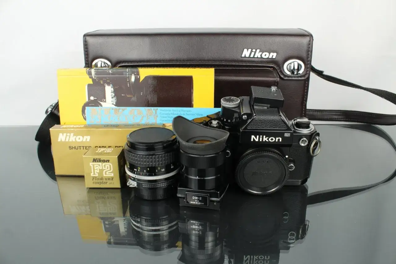 En svart Nikon F2 kamera med objektiv, blixtkopplare och originalf&ouml;rpackningar. En klassisk Nikon F2 f&ouml;r den kr&auml;sne fotografen.