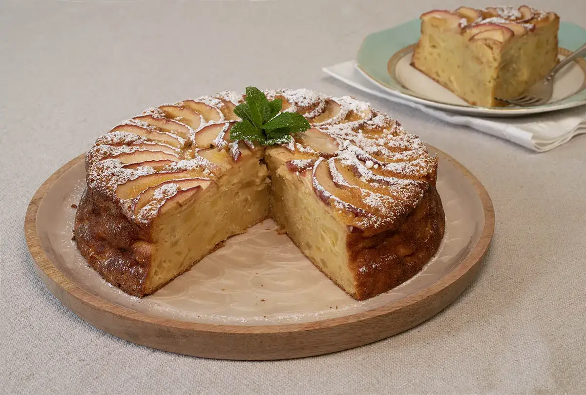 Tarta de manzana con azúcar glas y menta. Un trozo servido en plato, como un tesoro invisible aux pommes.