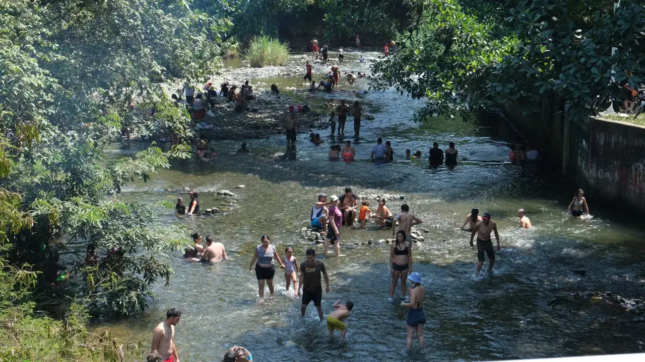Gente disfrutando del río, una excelente opción de qué hacer en Cali para refrescarse y pasar un día en familia.