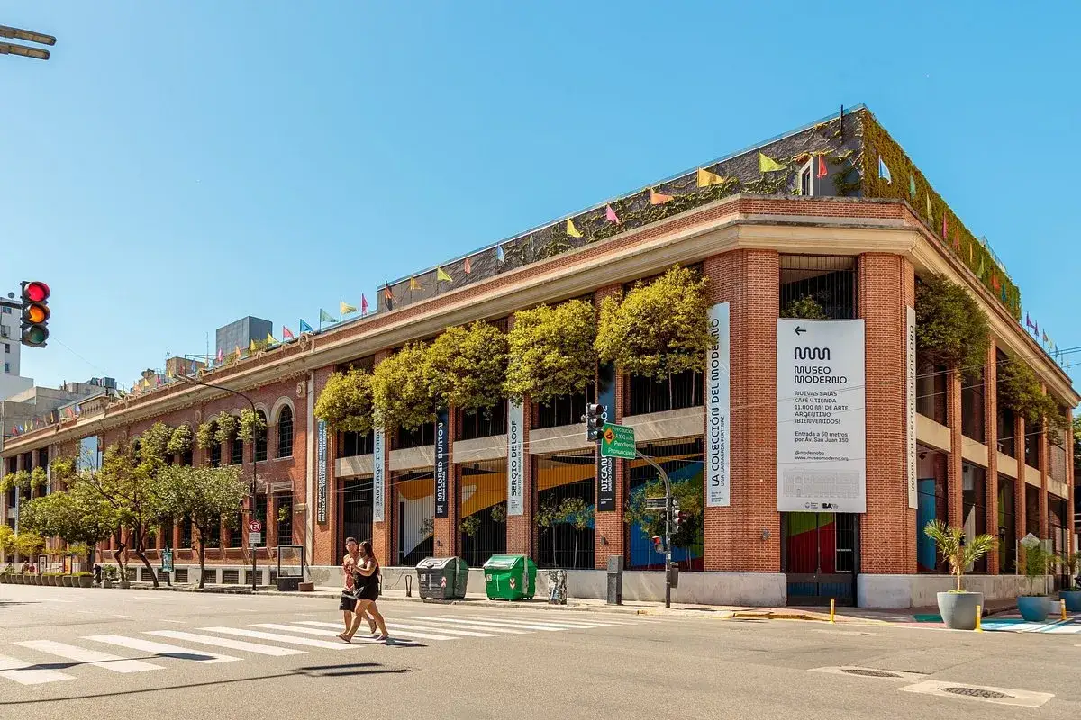 Museo Moderno, a prominent museum in Buenos Aires, features a brick facade adorned with trees and colorful flags.