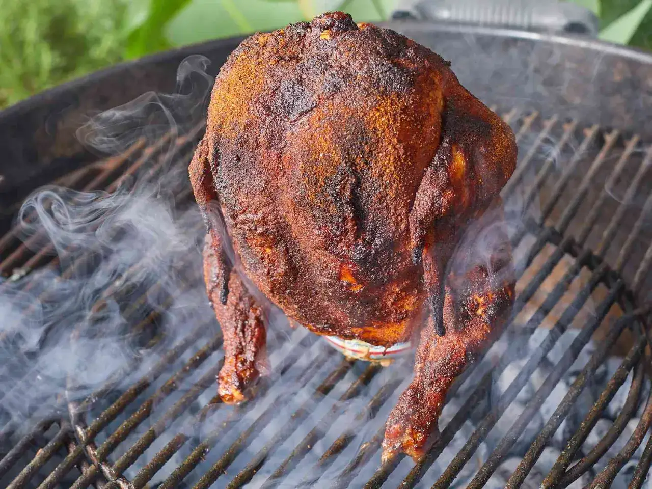 En saftig ölkyckling ryker på grillen, redo att serveras.